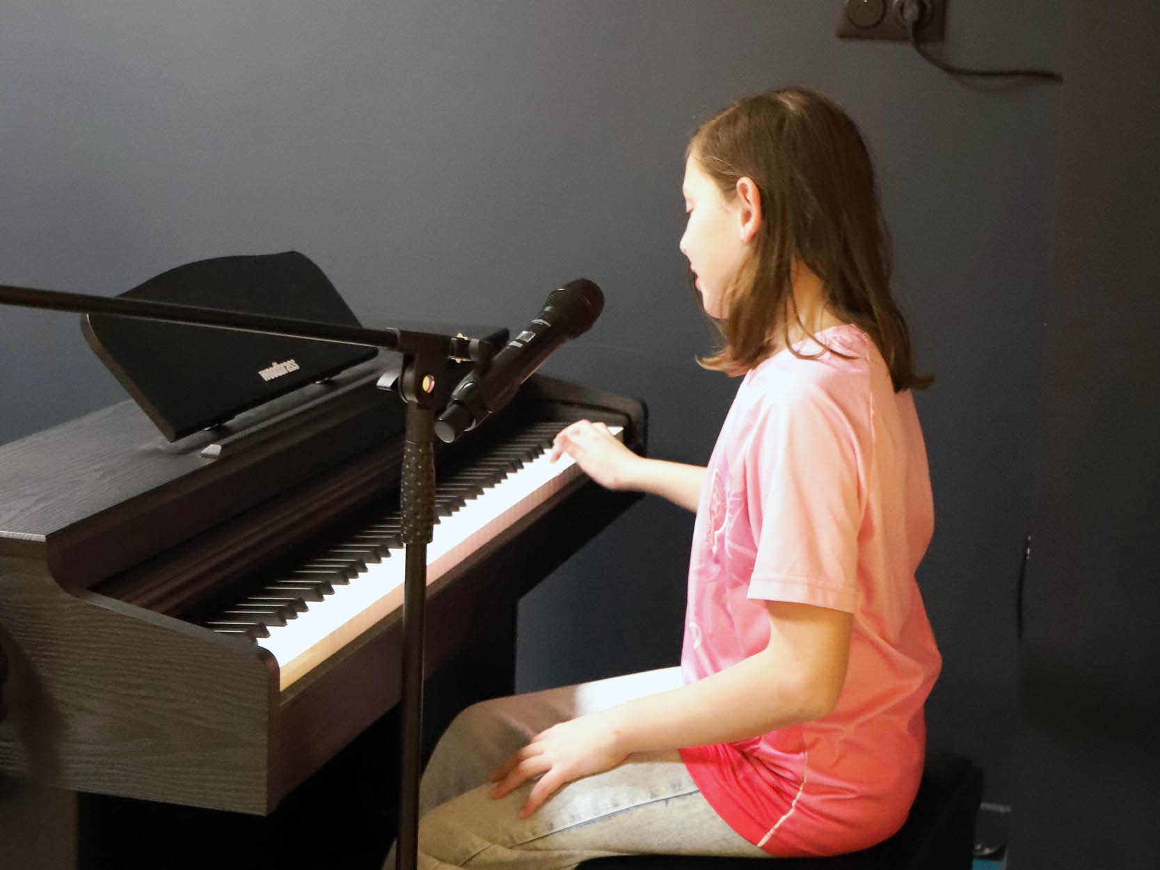 une jeune fille jouant du piano à la Cité des Petits Rêveurs